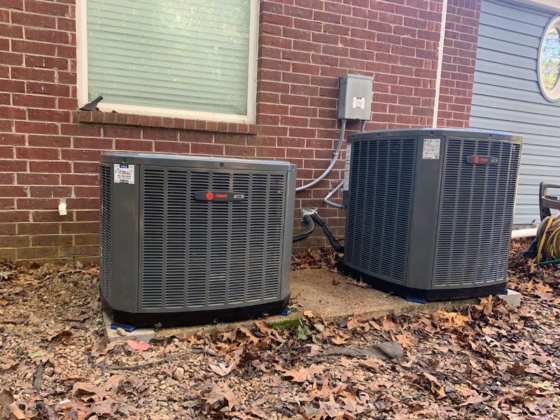 Air conditioner condensers beside a brick home